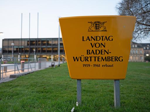Am Landtag von Baden-Württemberg sind Absperrungen zu sehen, im Vordergrund steht ein großes Schild mit der Aufschrift: "Landtag von Baden-Württemberg 1959-1961 erbaut"
