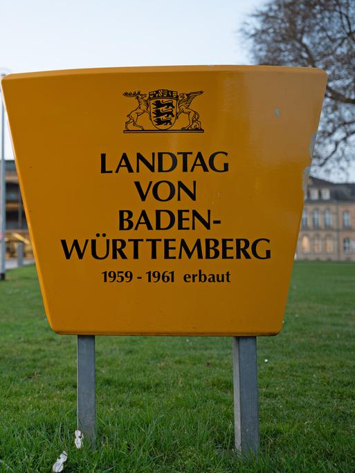 Am Landtag von Baden-Württemberg sind Absperrungen zu sehen, im Vordergrund steht ein großes Schild mit der Aufschrift: "Landtag von Baden-Württemberg 1959-1961 erbaut"