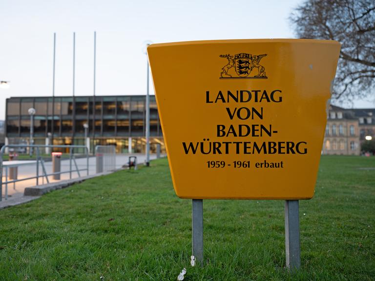 Am Landtag von Baden-Württemberg sind Absperrungen zu sehen, im Vordergrund steht ein großes Schild mit der Aufschrift: "Landtag von Baden-Württemberg 1959-1961 erbaut"