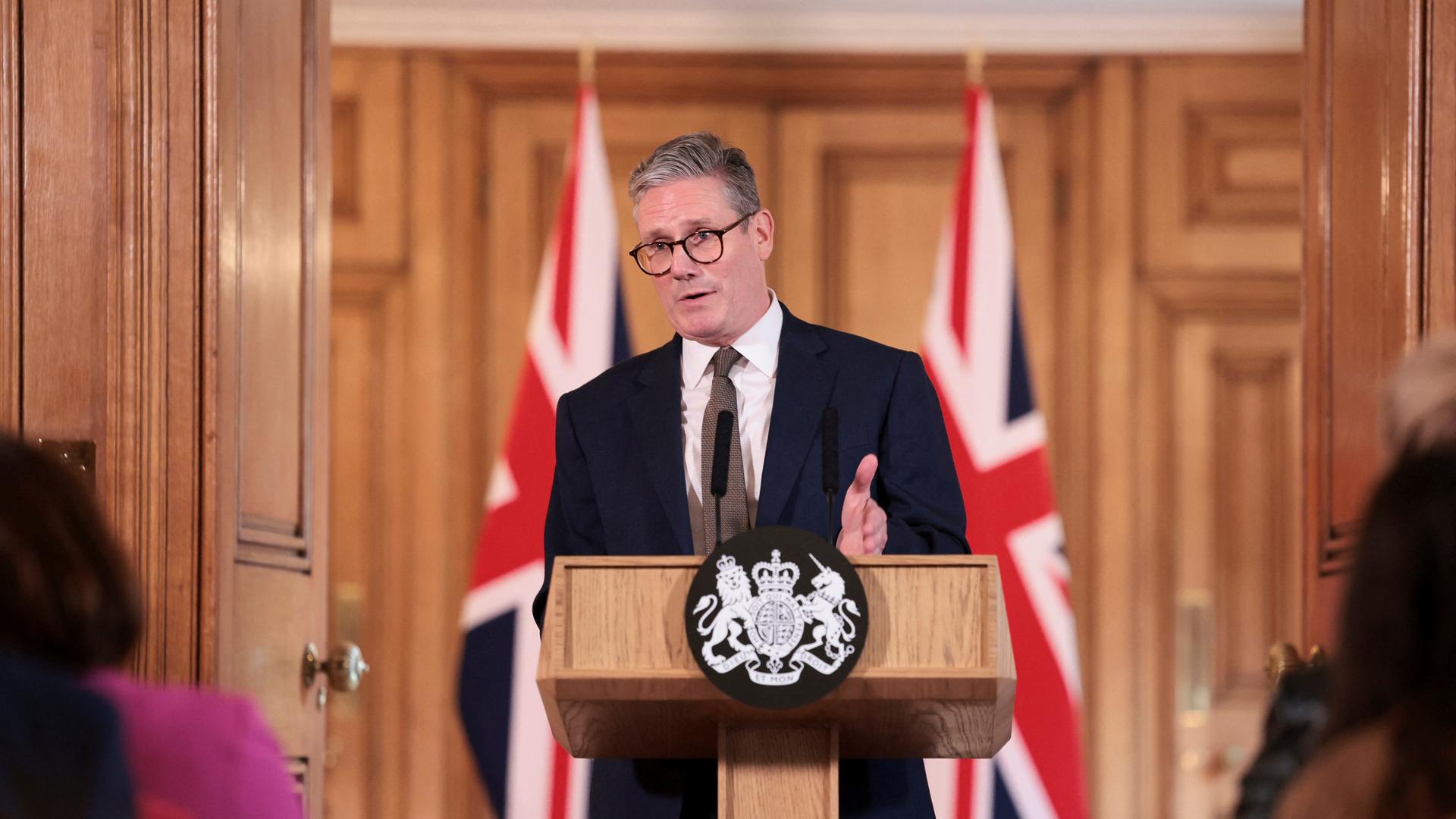 Der britische Premierminister Keir Starmer gibt in London eine Pressefkonferenz, er steht an einem Pult, im Hintergrund sind britische Flaggen zu sehen. Aufnahme vom 06.07.2024. 