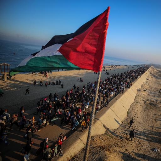 Menschenmassen unterwegs in den Norden des Gazastreifens mit der palästinensischen Flagge im Vordergrund