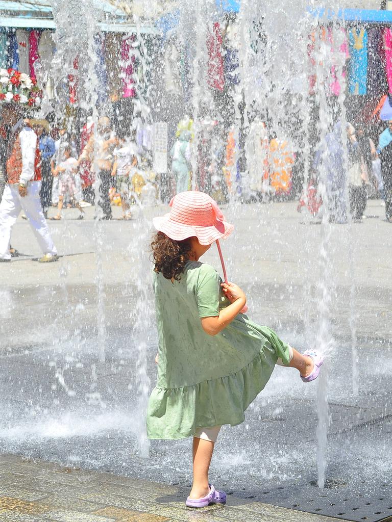Ein Kind ist von hinten zu sehen, wie es in der tunesischen Hauptstadt Tunis an einem Springbrunnen mit Wasser spielt.
