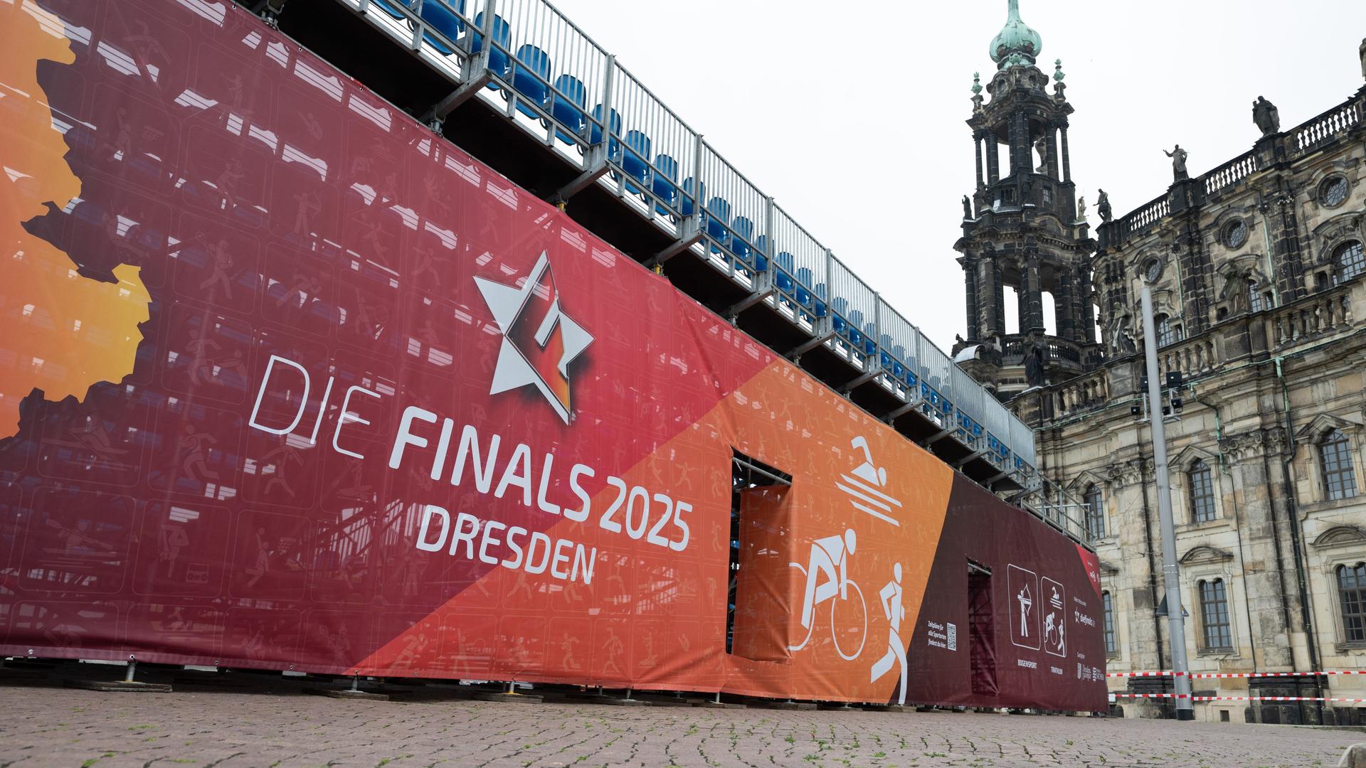 Ein Transparent mit der Aufschrift "Die Finals 2025" Dresden an einer Zuschauertribüne auf dem Theaterplatz vor der Katholischen Hofkirche.