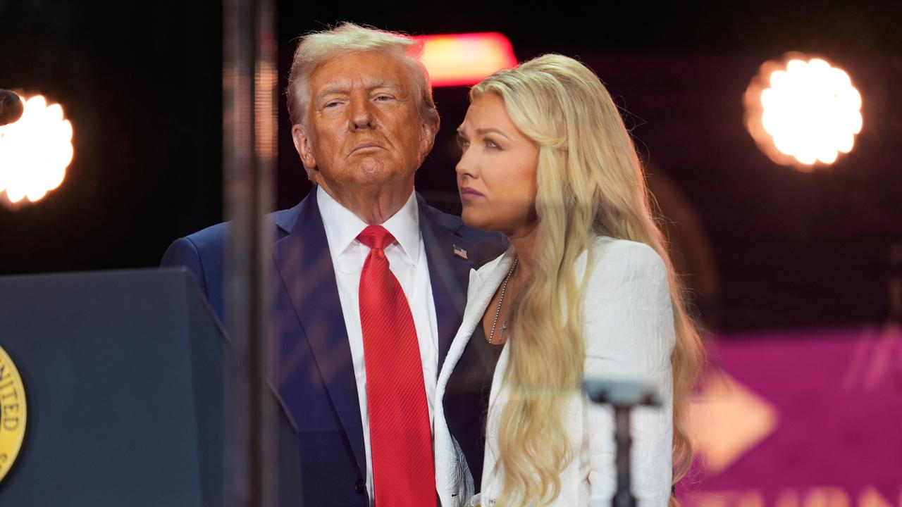 US-Präsident Trump steht mit der Witwe des erschossenen rechten Aktivisten Charlie Kirk bei der Trauerfeier auf der Bühne, beide blicken ernst. 
