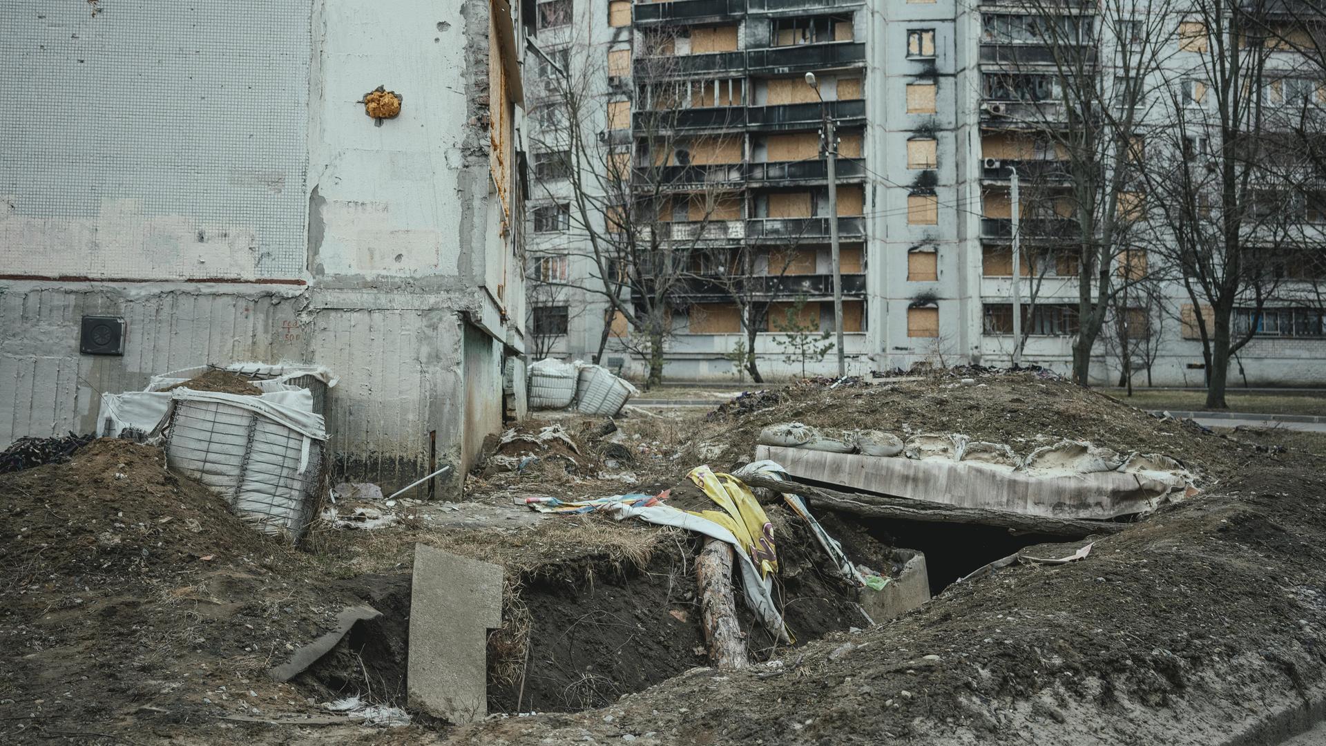 Schützengraben und zerstörte Wohngebäude in der ukrainischen Stadt Charkiw.