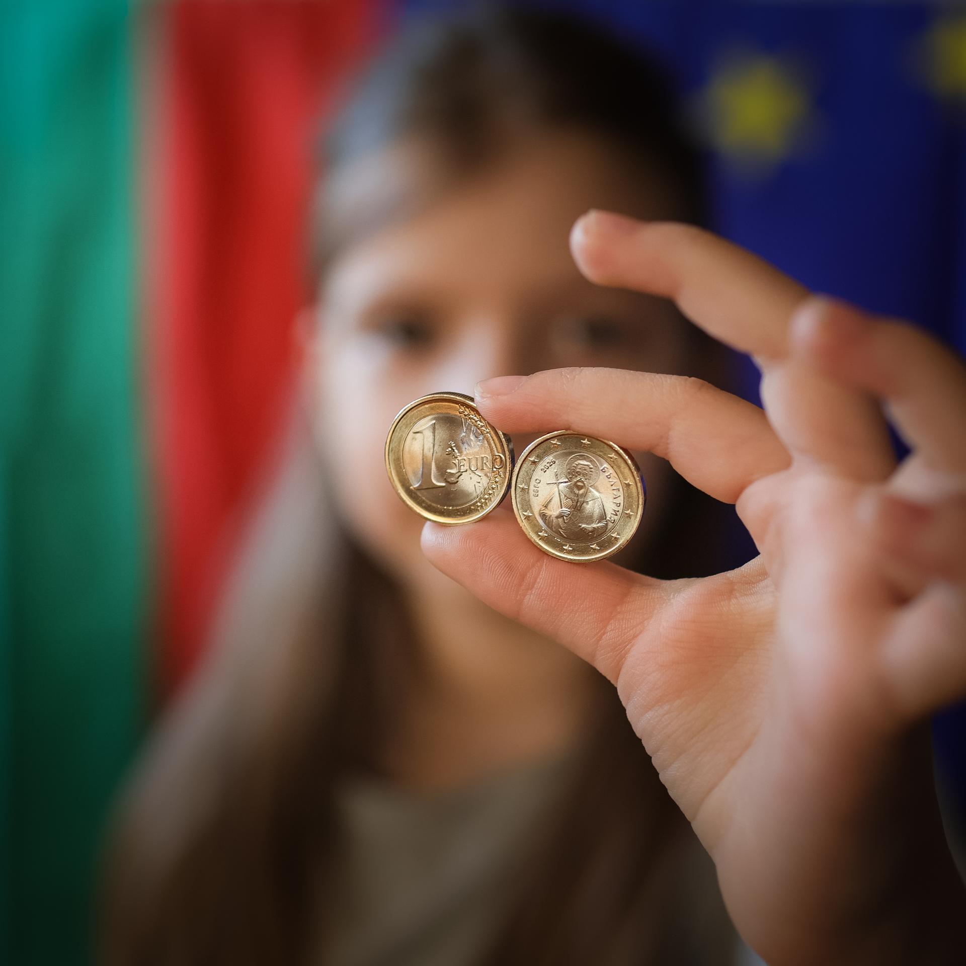 Ein Mädchen zeigt neue Euro-Münzen mit bulgarischen Symbolen. 