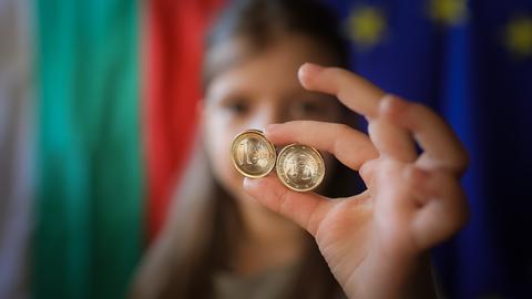 Ein Mädchen zeigt neue Euro-Münzen mit bulgarischen Symbolen. 