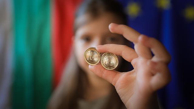 Ein Mädchen zeigt neue Euro-Münzen mit bulgarischen Symbolen. 