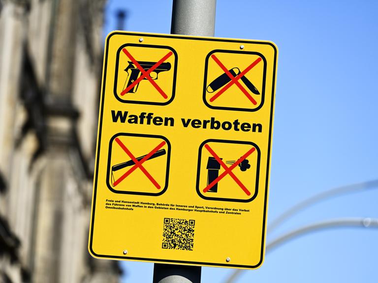 Auf einem Schild sind Piktogramme von durchgestrichenen Waffen zu sehen.