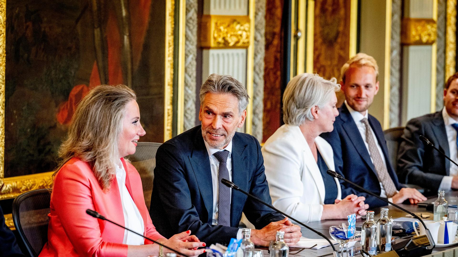 Ministerpräsident Dick Schoof sitzt mit Ministern seines neuen Kabinetts an einem Tisch.
