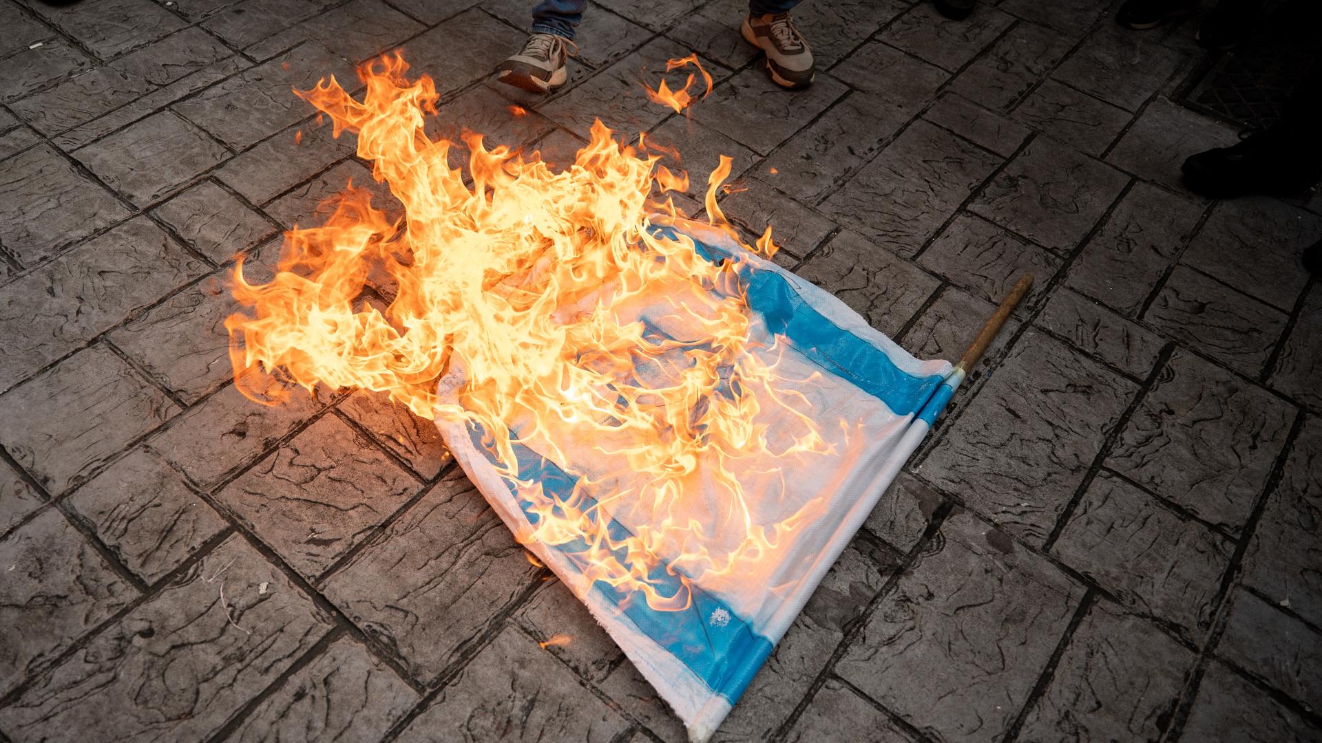 Demonstranten in Venezuela verbrennen eine israelische Flagge.
