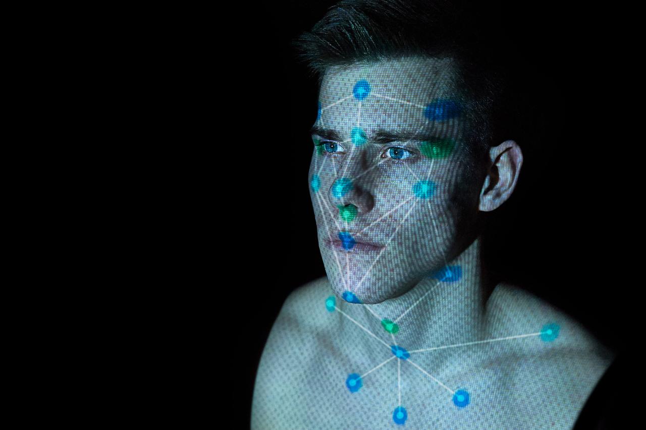 Illustration einer Gesichtserkennung. Zu sehen ist ein computer-animiertes männliches Gesicht mit erkennungsdienstlichen Markern und Strukturen.