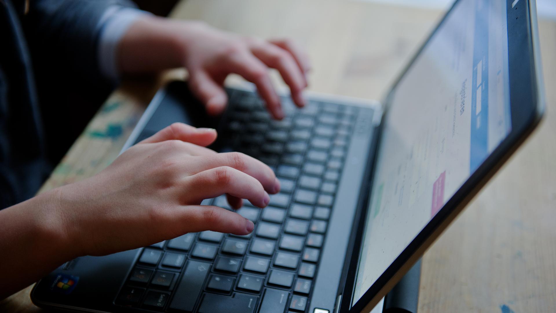 Ein junges Mädchen sitzt an einem Laptop.