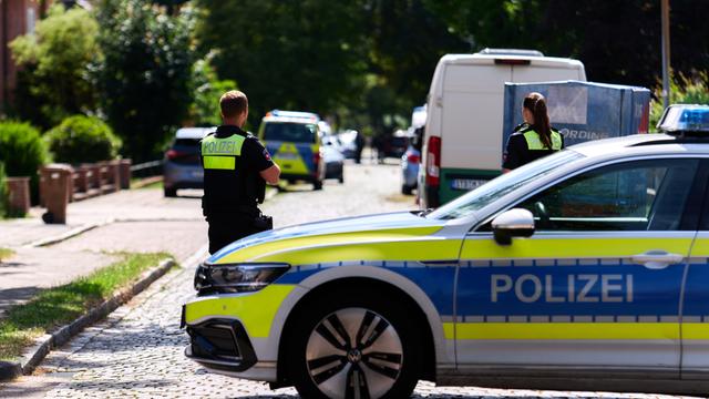 Polizisten stehen auf einer Straße vor dem Haus von der  Jugend-Hilfe in Stade. 