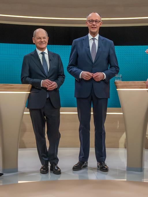 ARD-Moderatorin Sandra Maischberger (l-r), Bundeskanzler Olaf Scholz (SPD), Kanzlerkandidat Friedrich Merz (CDU) und die ZDF-Moderatorin Maybrit Illner stehen vor dem TV-Duell in einem Studio. 