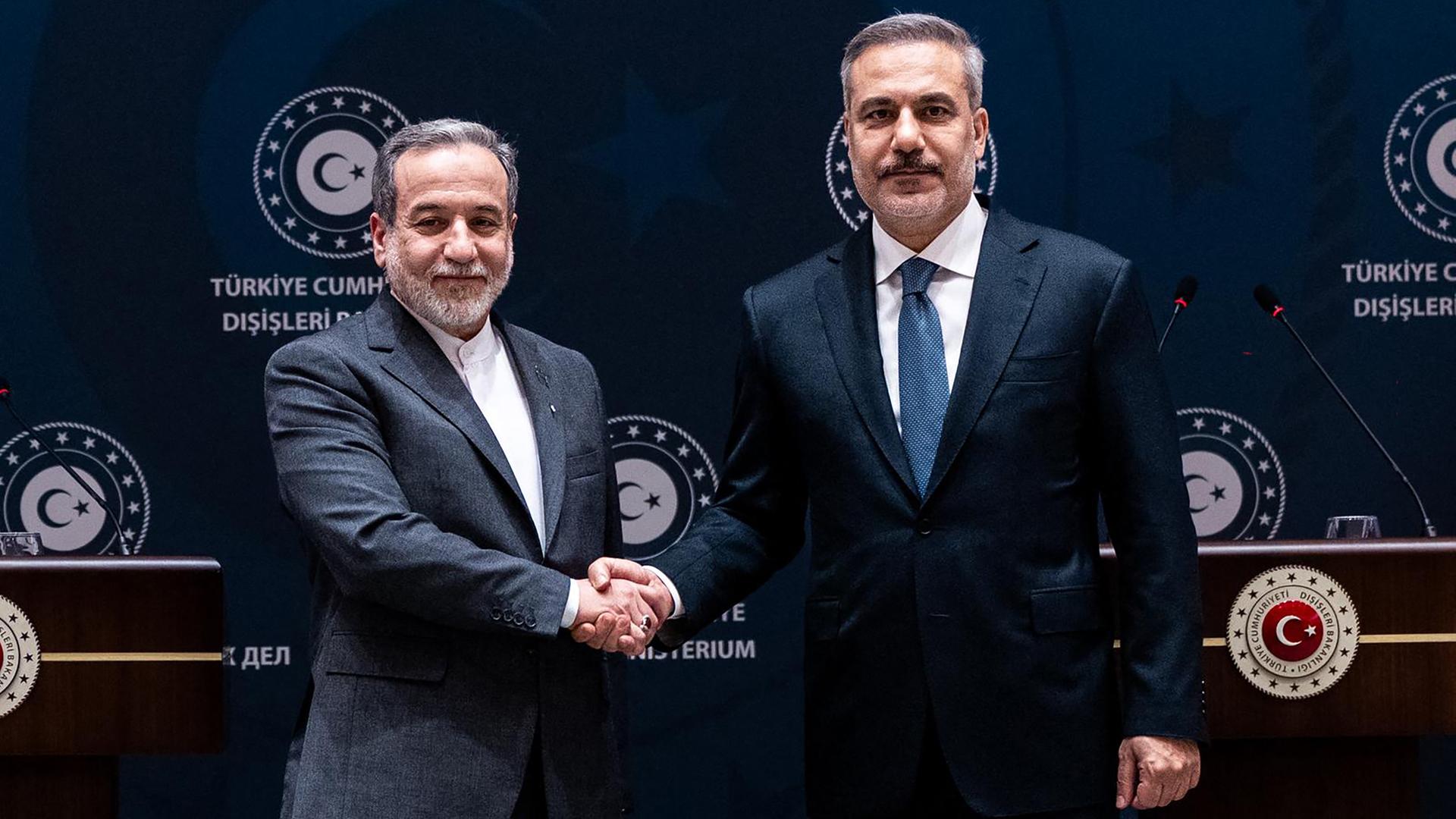 Die Außenminister des Iran und der Türkei, Araghtschi und Fidan, geben sich die Hand.
