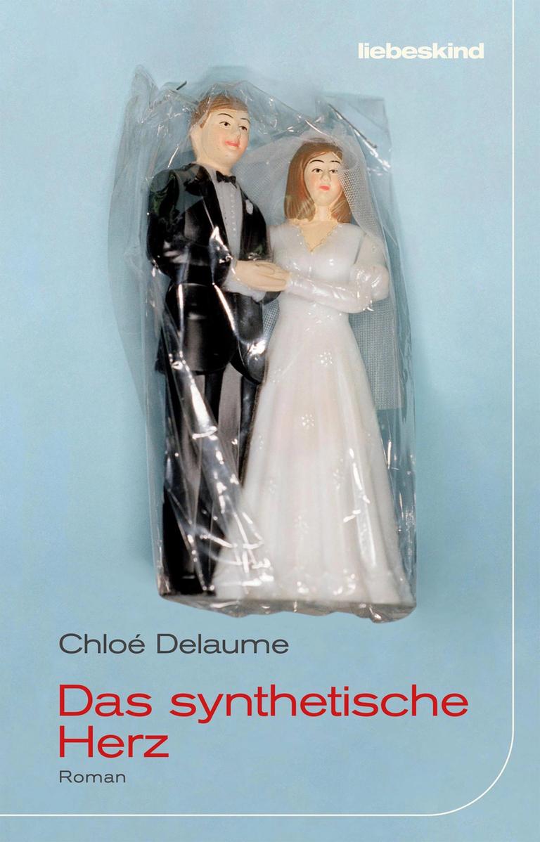 Buchumschlag des Romans "Das synthetische Herz" von Chloé Delaume, darauf ist vor blauem Hintergrund zwei eingewickelte Hochzeitspüppchen zu sehen, also ein Bräutigam im schwarzen Anzug und ein eine Brau in weißem Brautkleid. Buchumschlag des Romans "Das synthetische Herz" von Chloé Delaume, darauf ist vor blauem Hintergrund zwei eingewickelte Hochzeitspüppchen zu sehen, also ein Bräutigam im schwarzen Anzug und ein eine Brau in weißem Brautkleid.