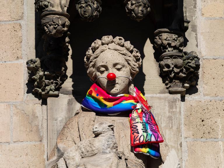 Mit Karnevalsschal und roter Pappnase drapierte ist die Heilige Agnes an der Agneskirche in Köln.