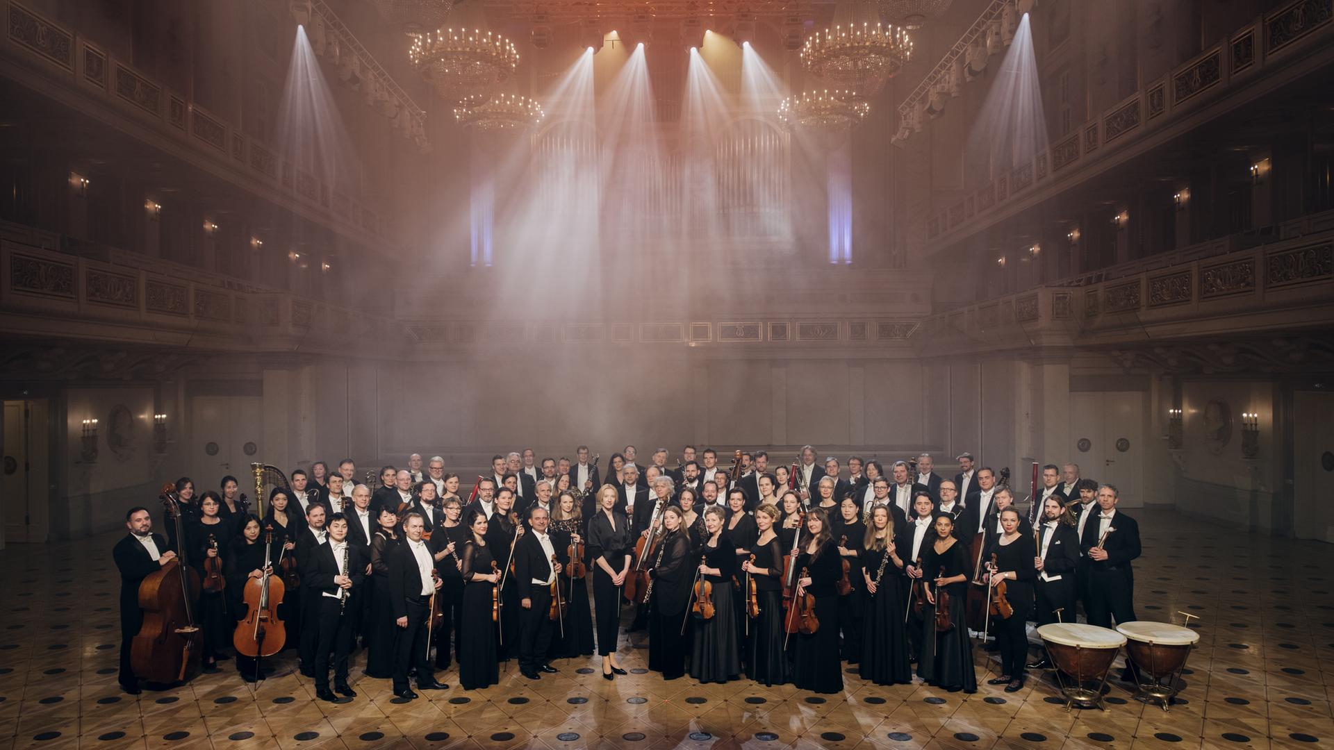 Das Konzerthausorchester Berlin mit Dirigentin Joana Mallwitz stehen aufgereiht im großen Saal des Konzerthauses Berlin. 
