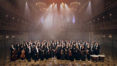 Das Konzerthausorchester Berlin mit Dirigentin Joana Mallwitz stehen aufgereiht im großen Saal des Konzerthauses Berlin. 