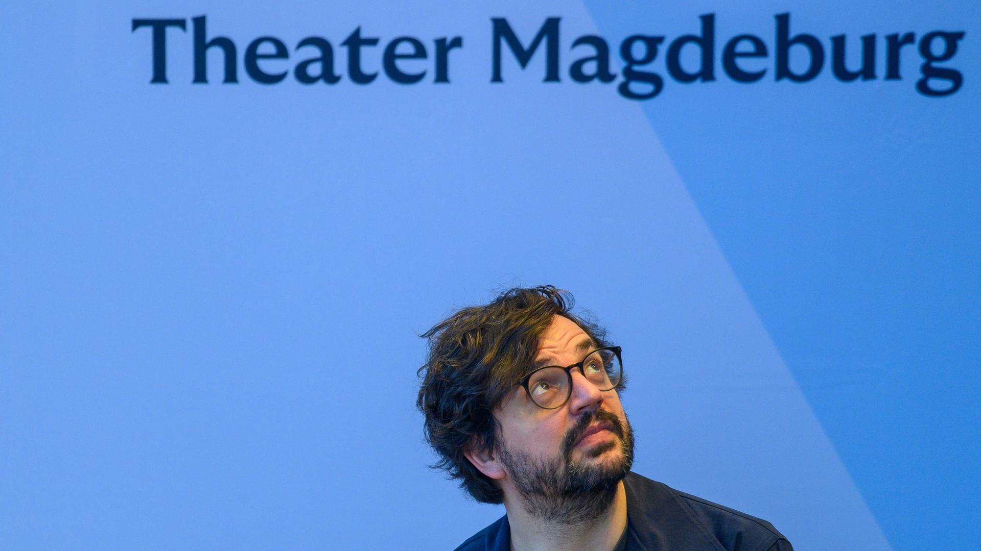 Julien Chavaz, der Generalintendant und Operndirektor am Theater Magdeburg sitzt auf dem Podium einer Pressekonferenz und dreht sich zu dem Schriftzug "Theater Magdeburg" um. Julien Chavaz, der Generalintendant und Operndirektor am Theater Magdeburg sitzt auf dem Podium einer Pressekonferenz und dreht sich zu dem Schriftzug "Theater Magdeburg" um.