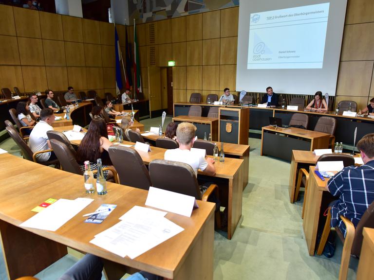 Jugendliche sitzen in einem Jugendparlament.