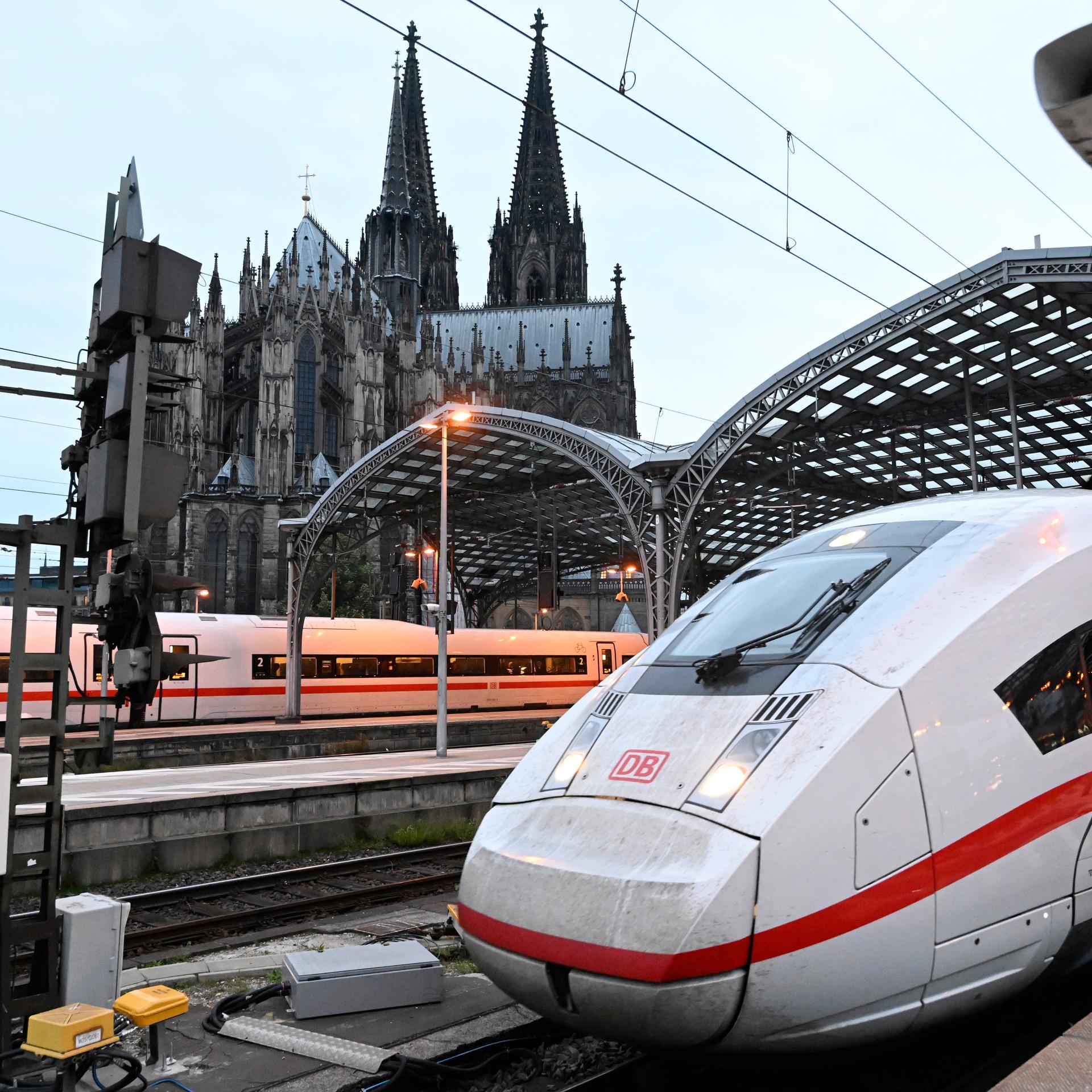 Ein ICE-Zug der Deutschen Bahn verlässt den Kölner Hauptbahnhof. Im Hintergrund ist der Dom.