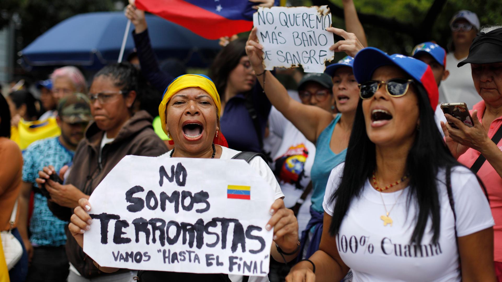 Venezuela, Caracas: Eine Frau hält ein Schild mit der spanischen Aufschrift "Wir sind keine Terroristen", während sie mit anderen Anhängern auf die Ankunft der Oppositionsführerin Maria Corina Machado wartet.