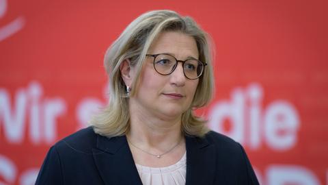 Die saarländische Ministerpräsidentin Anke Rehlinger (SPD) vor rotem Hintergrund
