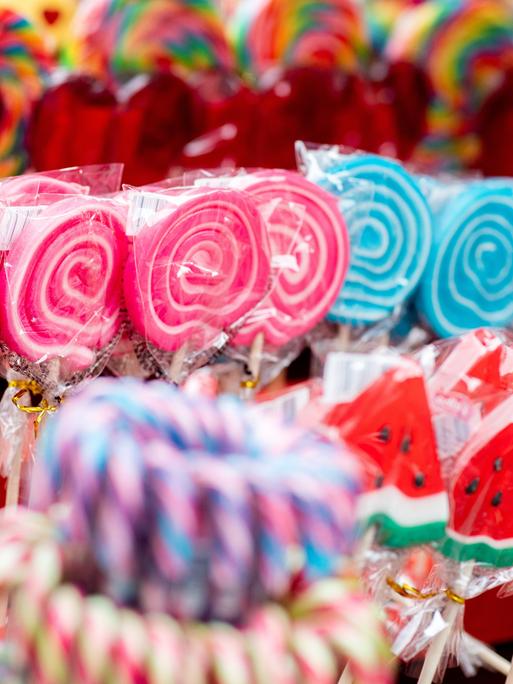 Bunte Lutscher werden während eines Volksfestes an einem Stand zum Kauf angeboten.