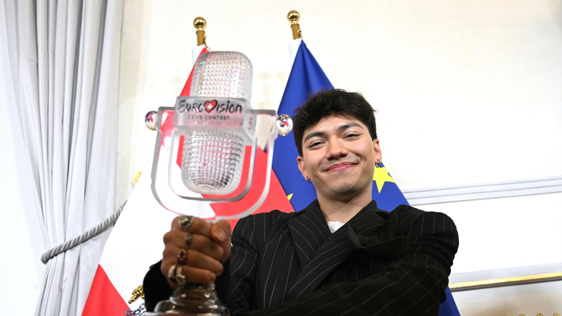 ESC-Sieger JJ zeigt die ESC-Trophae, dahinter die Flagge Österreichs und der EU ESC-Sieger JJ zeigt die ESC-Trophae, dahinter die Flagge Österreichs und der EU