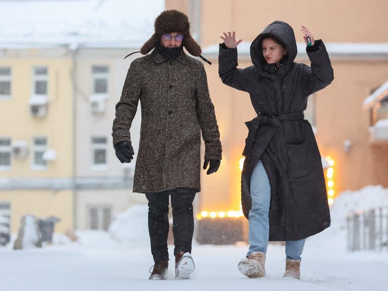 DIESES FOTO WIRD VON DER RUSSISCHEN STAATSAGENTUR TASS ZUR VERFÃGUNG GESTELLT. [RUSSIA, MOSCOW - DECEMBER 10, 2023: A man and a woman walk in a street in central Moscow. Sofya Sandurskaya/TASS]