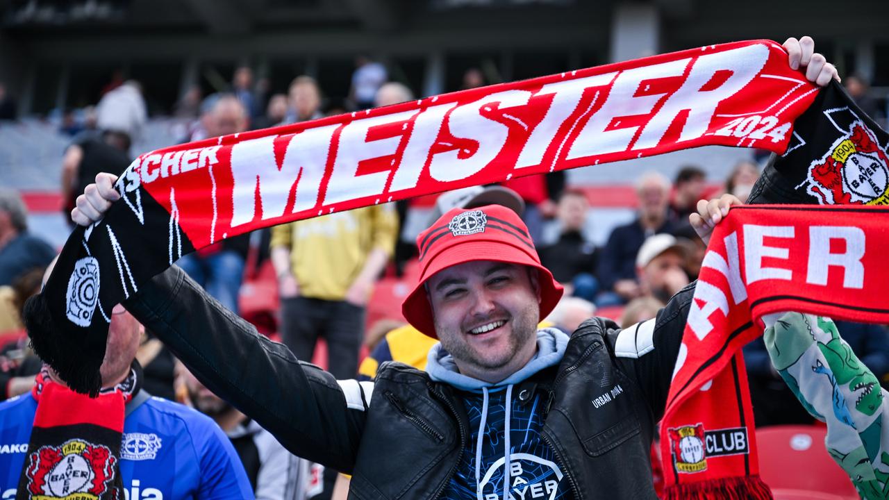 Fan von Bayer Leverkusen mit Fanschal mit der Aufschrift "Meister"