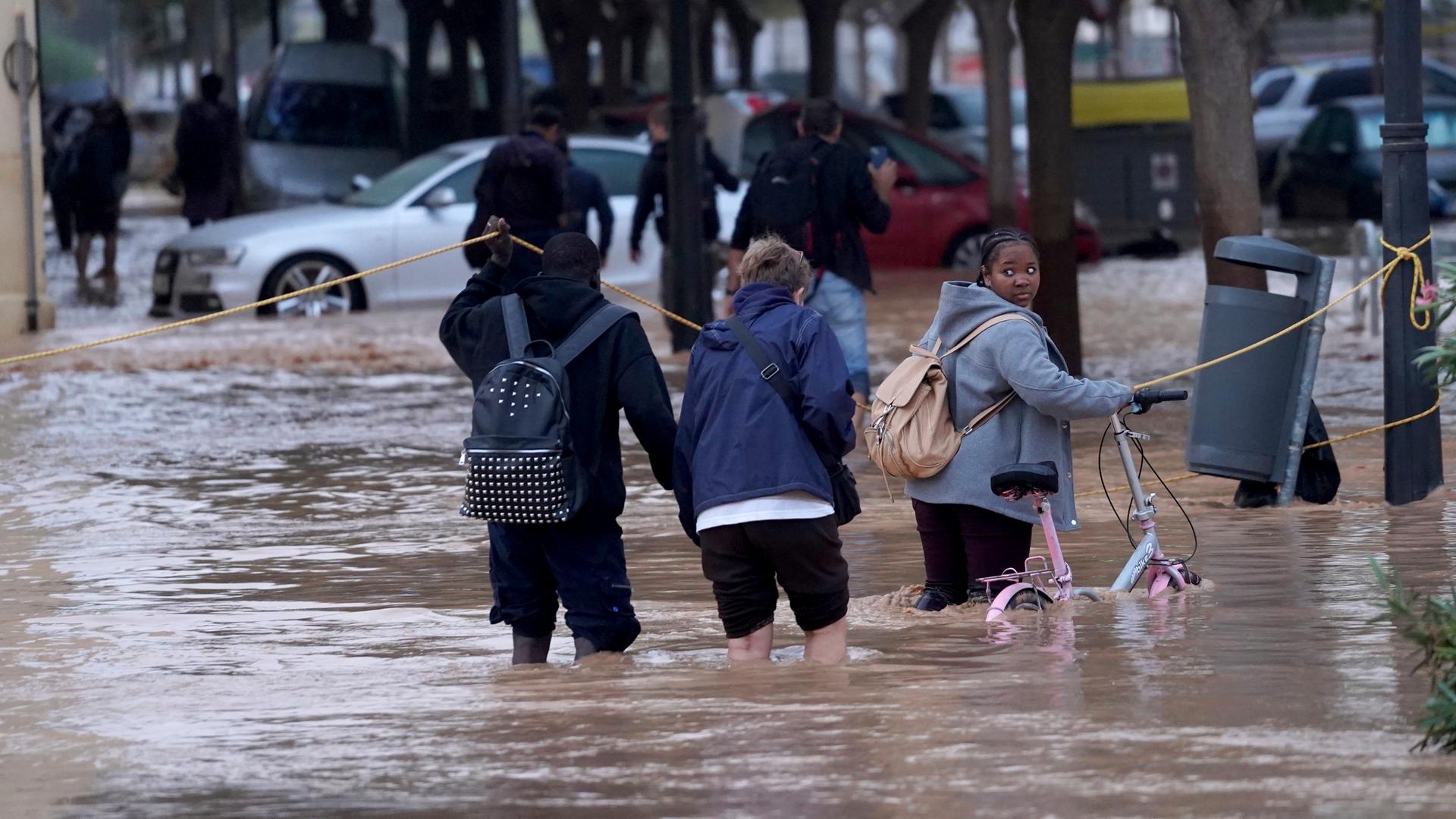 Spanien, Valencia: Menschen gehen durch überflutete Straßen. Spanien, Valencia: Menschen gehen durch überflutete Straßen.