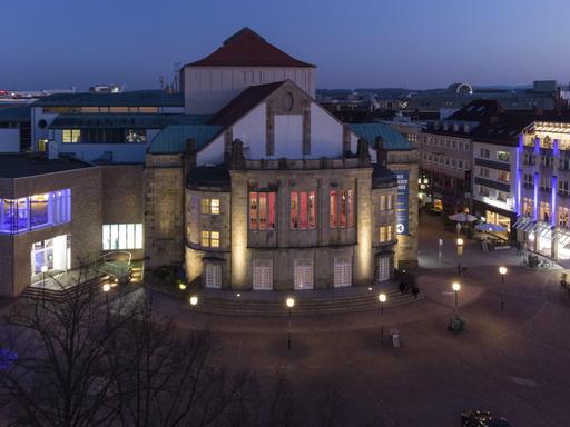 Luftaufnahme vom erleuchteten Theater Osnabrück am Abend 