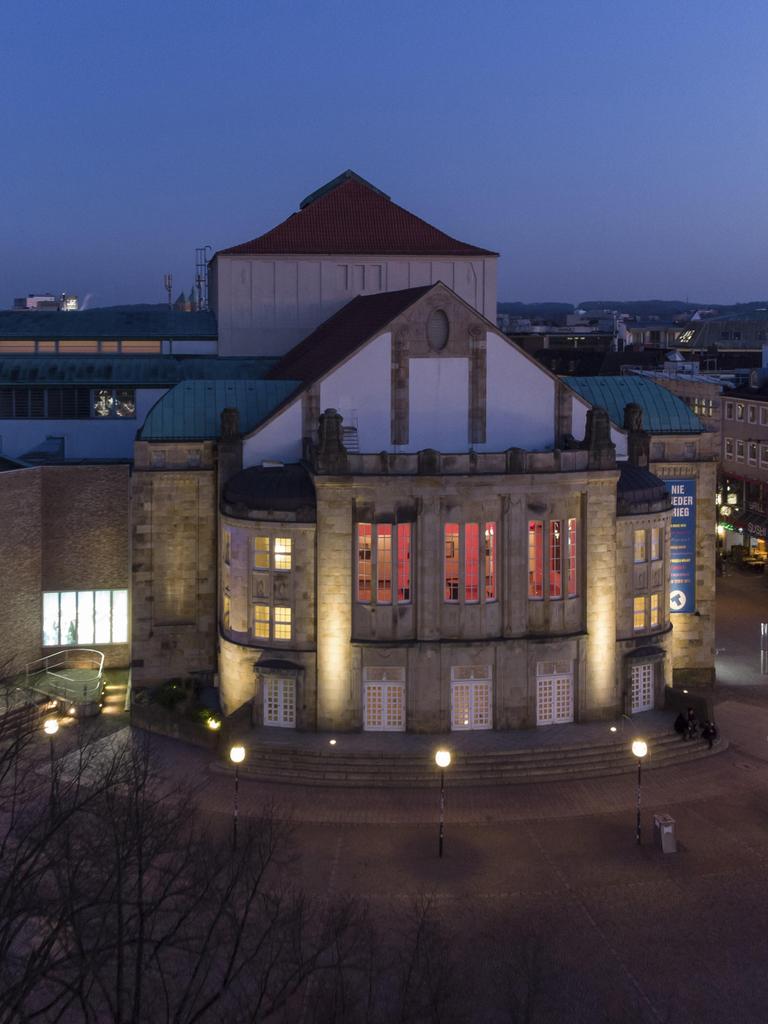 Luftaufnahme vom erleuchteten Theater Osnabrück am Abend 