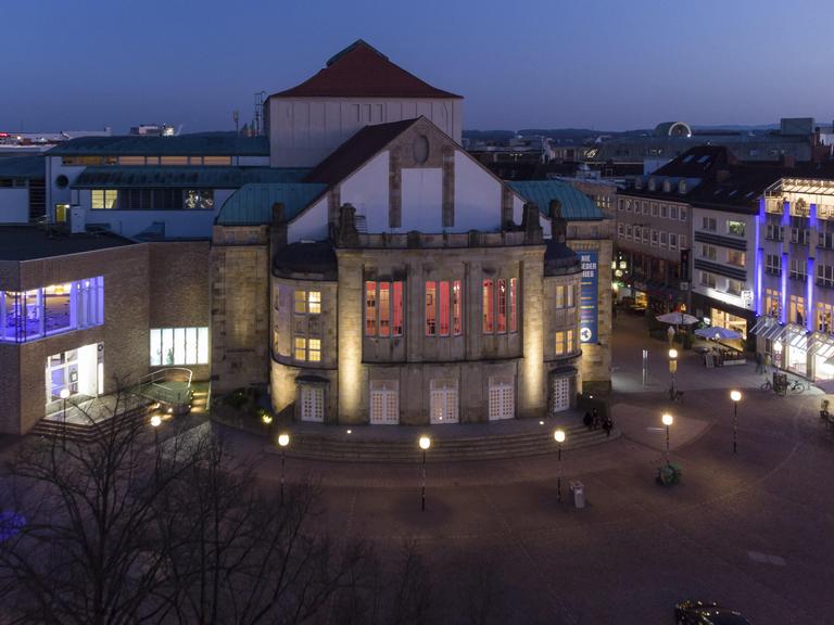Luftaufnahme vom erleuchteten Theater Osnabrück am Abend 