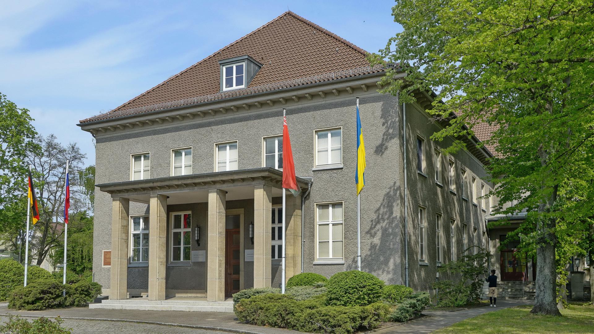 Blick auf das Deutsch-Russische Museum in Berlin-Karlshorst, vor dem die deutsche, die russische, die ukrainische und die belarussiche Flagge zu sehen sind.