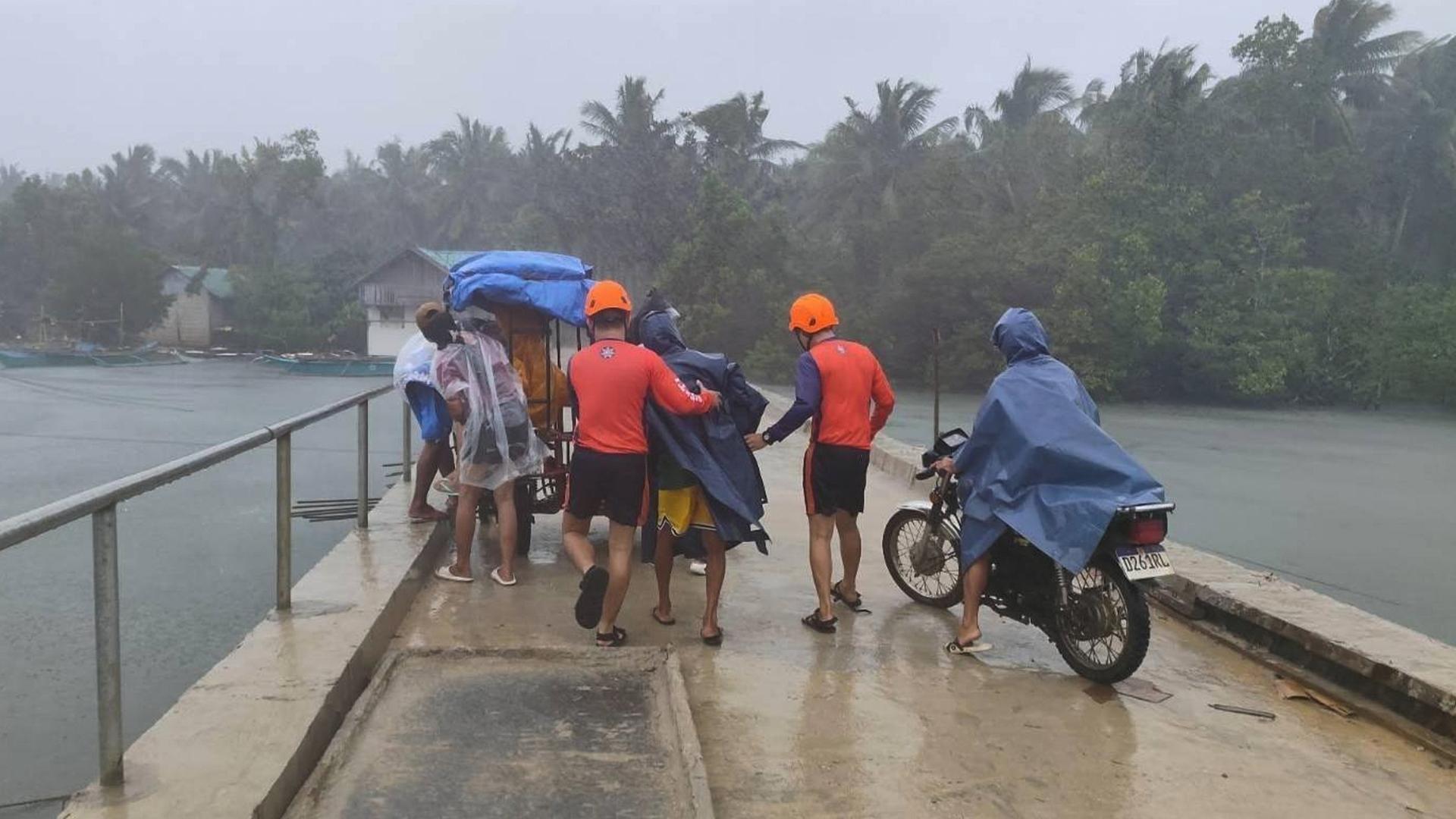 Auf einer Brücke stehen Menschen im Regen. Auf einer Brücke stehen Menschen im Regen.