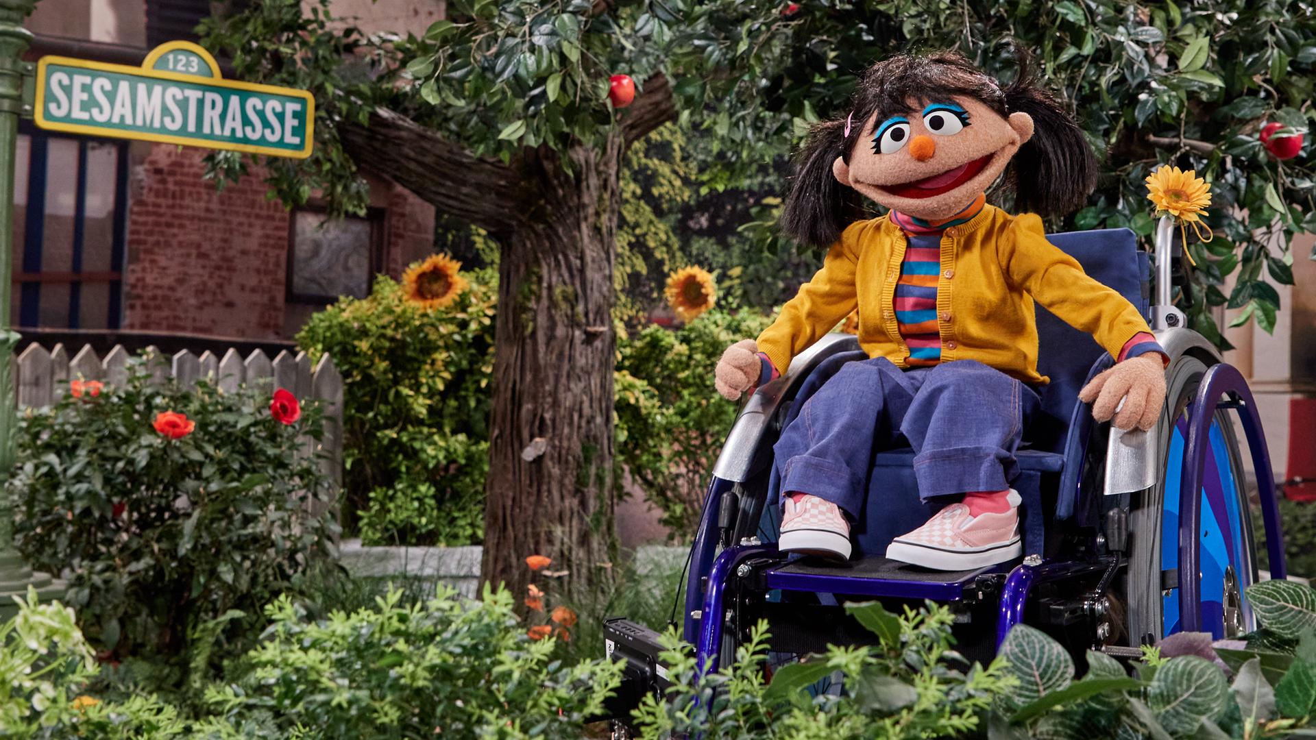 Die Puppe Elin, neue Bewohnerin der Sesamstraße, sitzt in einem Rollstuhl