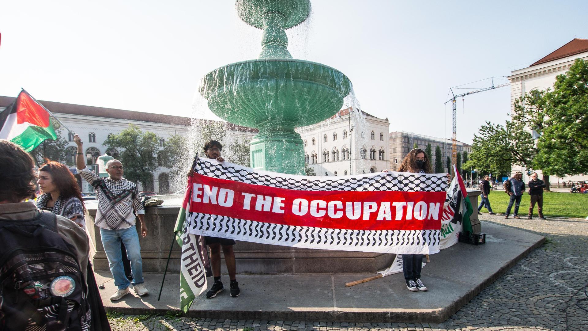 Propalästinensische Demonstration an der LMU München. Auf einem Banner steht "End the Occupation" (Beendet die Besatzung).