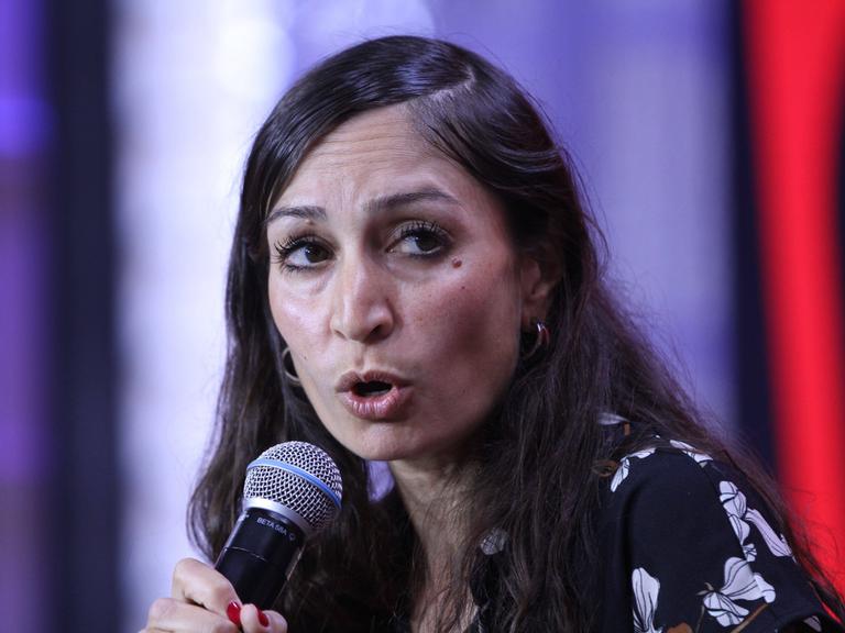 Die Politikwissenschaftlerin, Journalistin und Ärztin Gilda Sahebi spricht im Rahmen einer Podiumsdiskussion auf der Digitalmesse re:publica 2023 in Berlin in ein Handmikrofon.