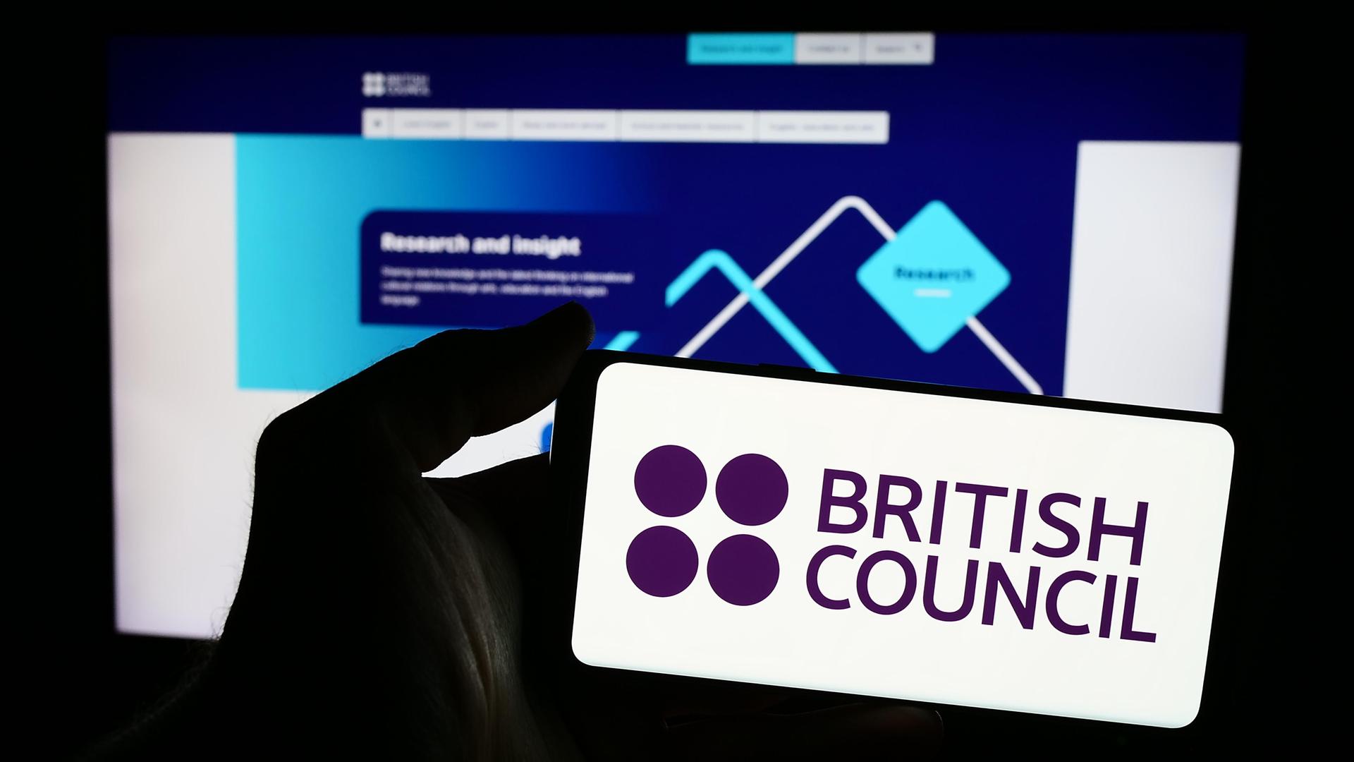 Illustration: Eine Hand hält ein Smartphone mit der Webseite des British Council.
