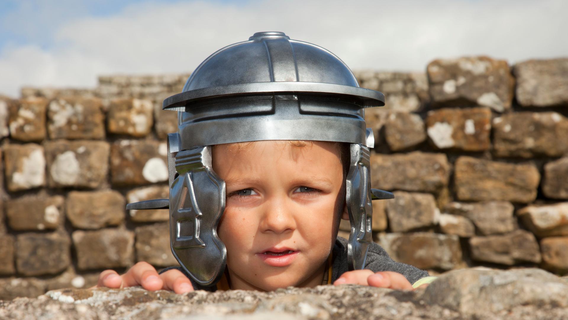 Ein Junge mit einem römischen Helm