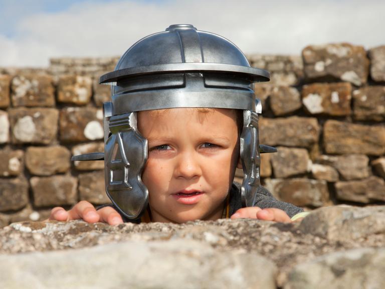 Ein Junge mit einem römischen Helm