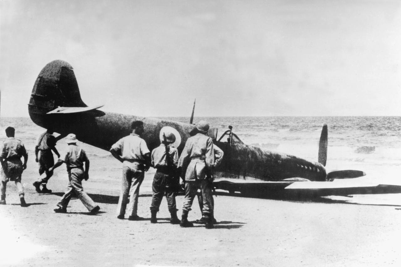 Angehörige der israelischen Küstenwache untersuchen ein im Mai 1948 an der Küste bei Tel Aviv niedergegangenes ägyptisches Flugzeug.