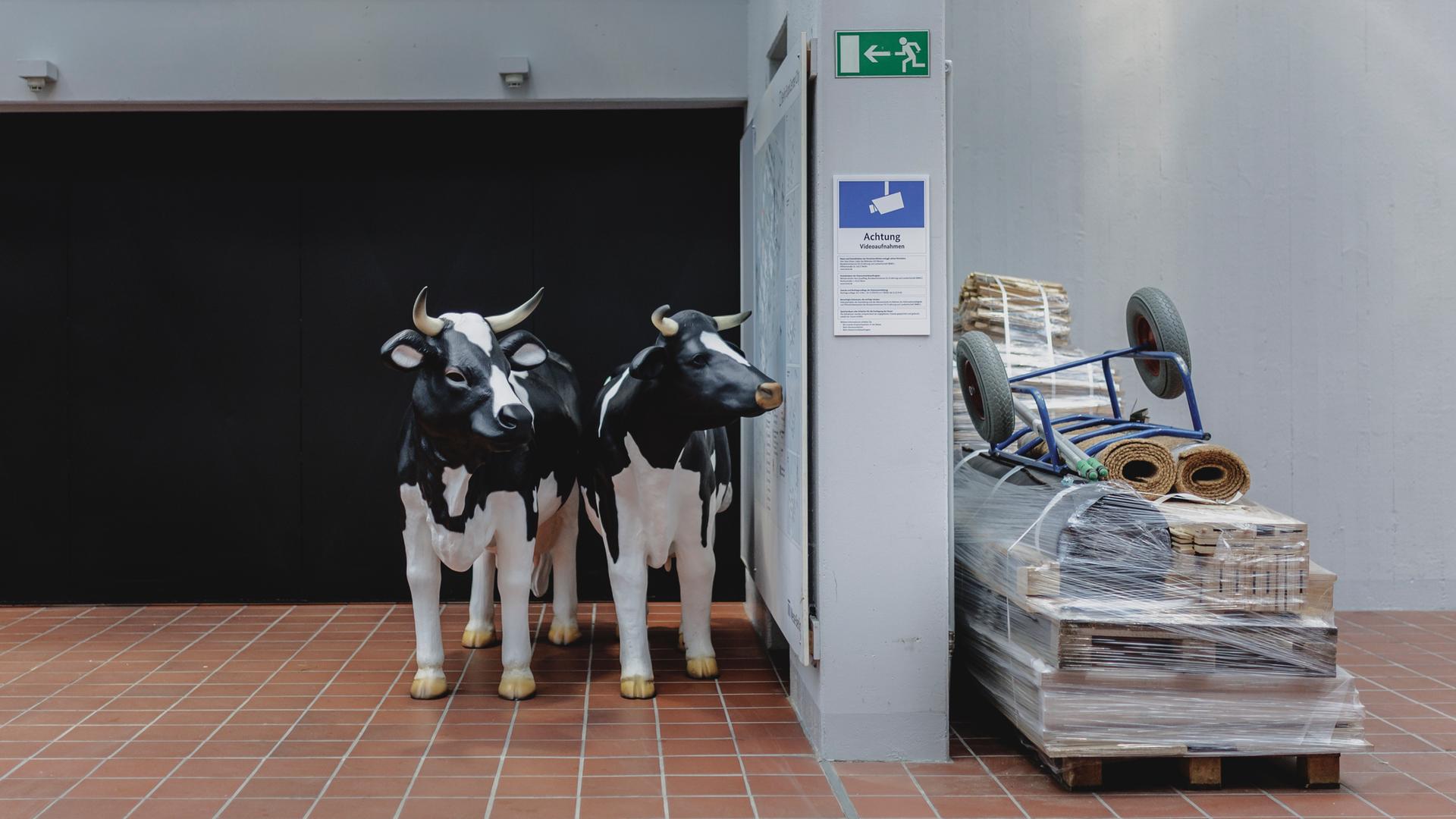 Kühe aus Kunststoff stehen vor einer Messehalle im Rahmen der Internationalen Grünen Woche in Berlin.