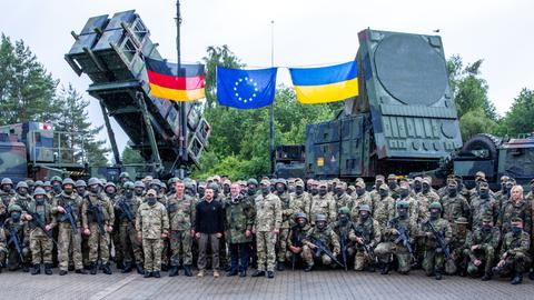 Der ukrainische Präsident Selenskyj und Bundesverteidigungsminister Pistorius stehen mit deutschen und ukrainischen Soldaten vor Flugabwehrraketensystemen vom Typ Patriot.
      