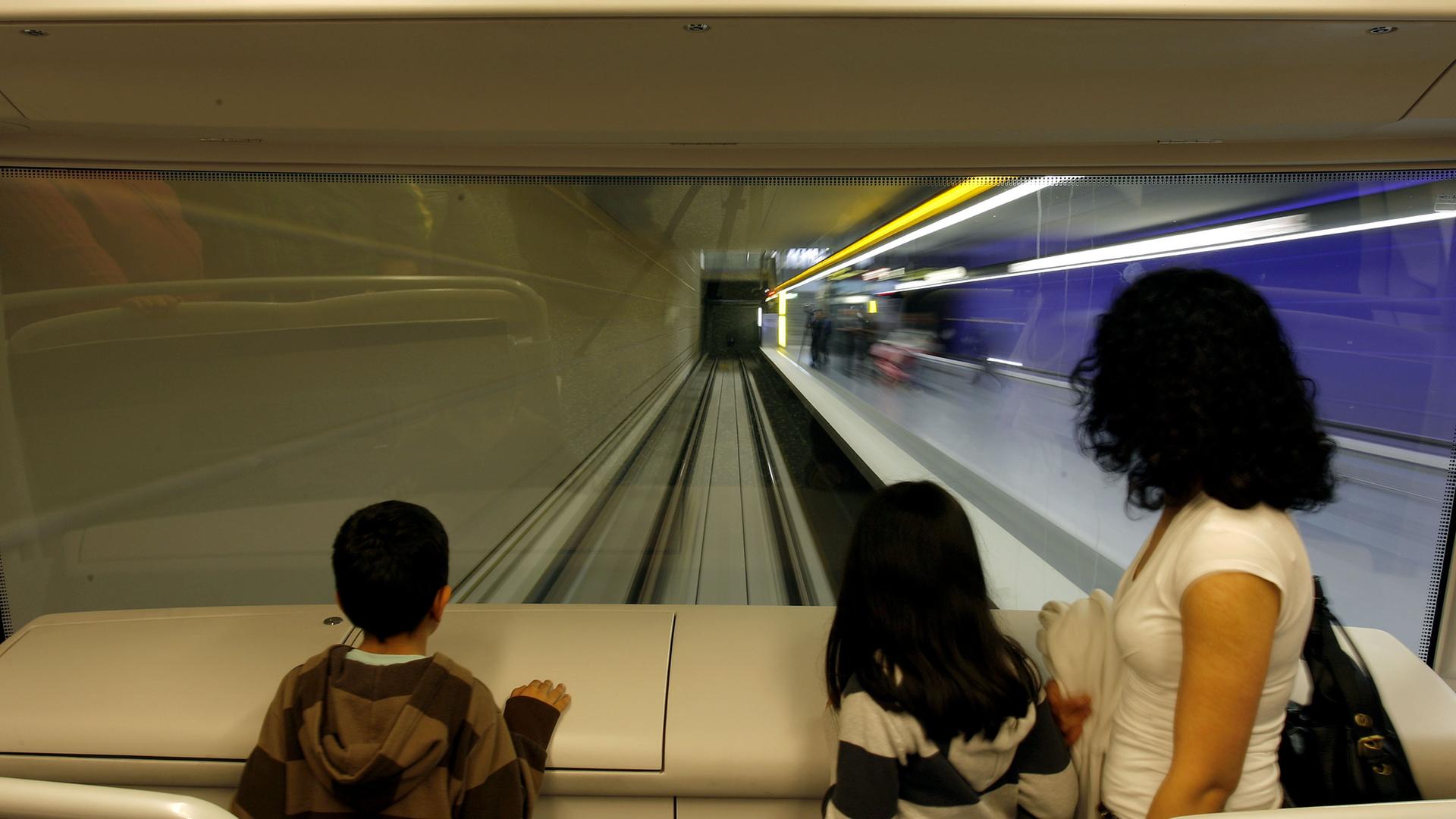 An der Frontscheibe mit direktem Blick auf die Tunnelstrecke steht ein Frau mit ihren zwei Kindern am Sonntag in Nürnberg (Mittelfranken) in der ersten vollautomatischen U-Bahn