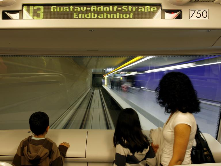 An der Frontscheibe mit direktem Blick auf die Tunnelstrecke steht ein Frau mit ihren zwei Kindern am Sonntag in Nürnberg (Mittelfranken) in der ersten vollautomatischen U-Bahn